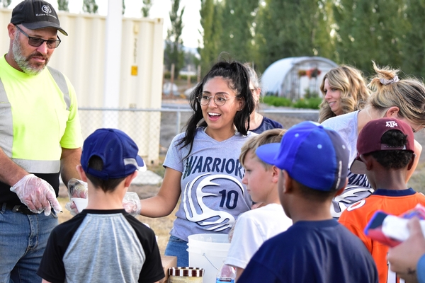 Students and adults serving ice cream to others.