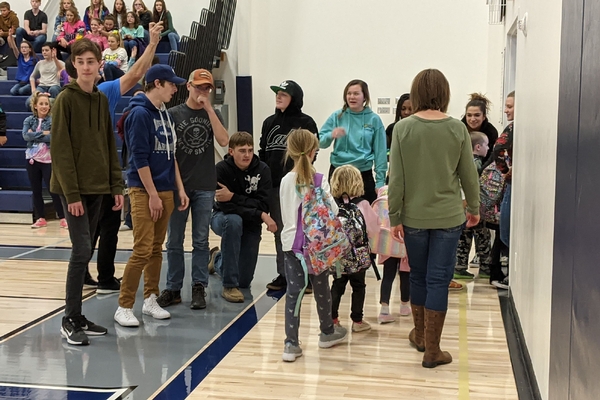 High school students greeting elementary students.