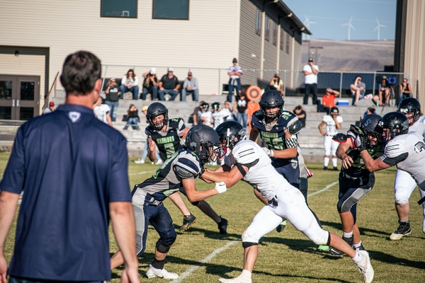 Football game with coach watching.