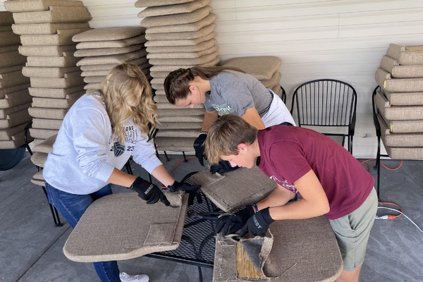 High School students reupholstering chairs.